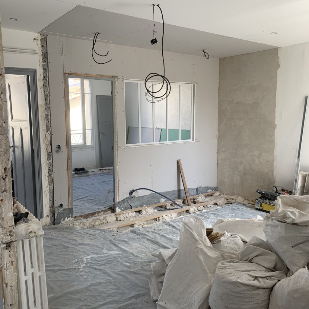 photo d'un chantier de rénovation d'un appartement avec démolition de cloison, pose de verrière et raccord de parquet au sol